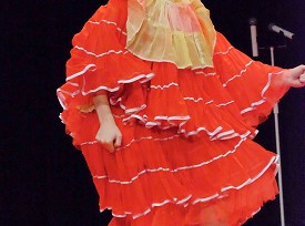 A dancer in an oversized red costume with white trimmings